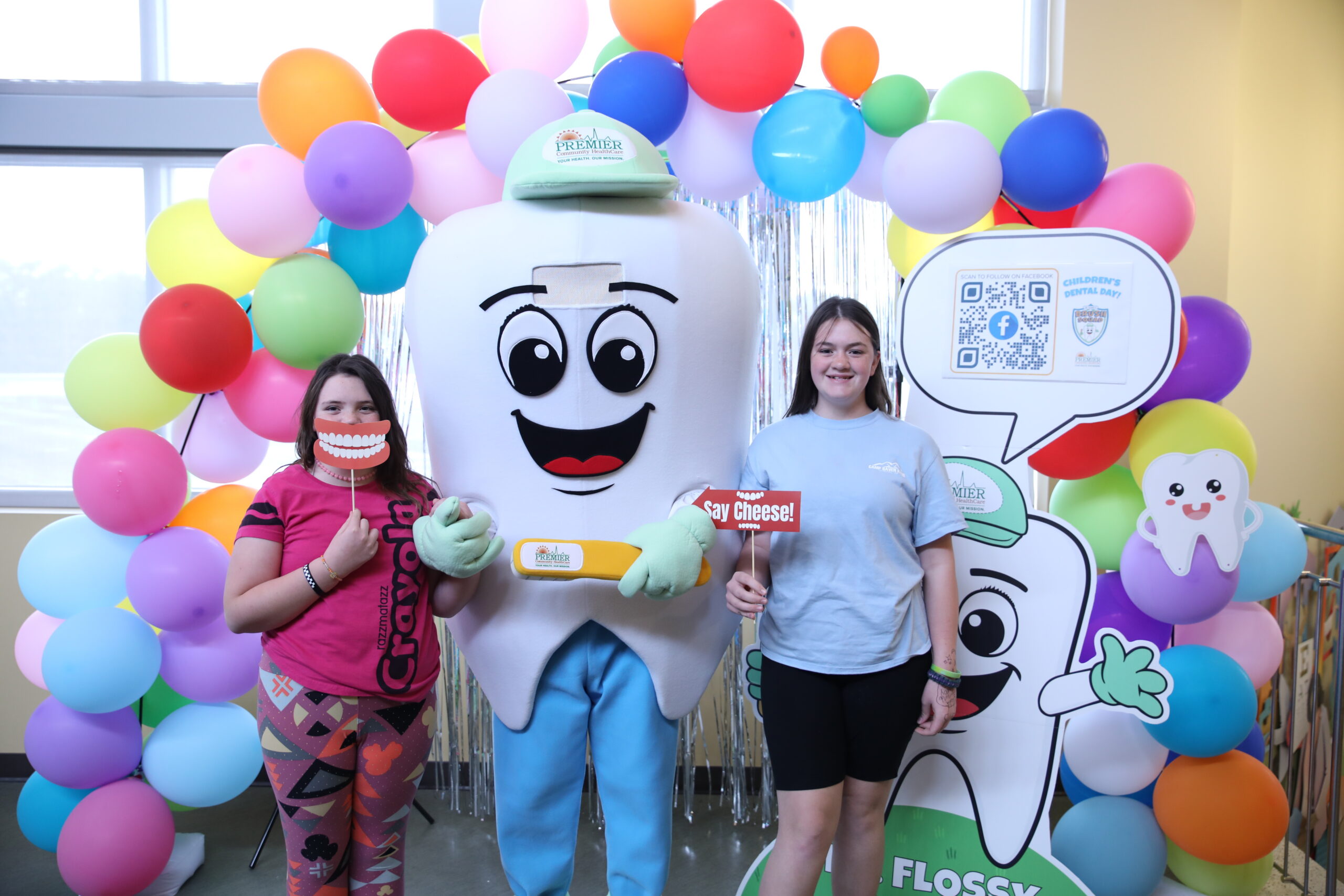 Children take picture with Dr. Flossy a photo booth with props.