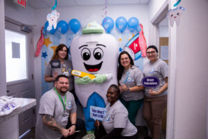The brush squad takes a break to take a picture with Dr. Flossy.